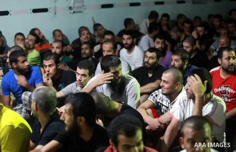 Palestinian inmates participate a prayer during the holy month of Ramadan at prison controlled by the Hamas police in Gaza city on 29 July 2012. Hamas police released more than 150 criminal inmates before the fasting mon...