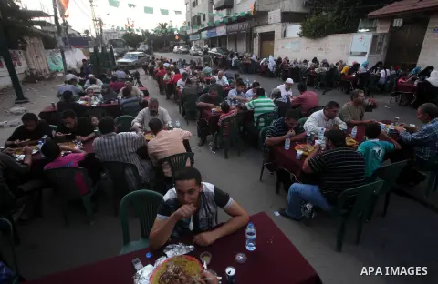 Families of Palestinian prisoners in Israeli jails attend the collective breaking fast organized by the Association of "Wa'ed" and funded by the Turkish relief "IHH" in front of the Red Cross headquarters during the holy...