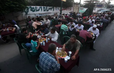 Families of Palestinian prisoners in Israeli jails attend the collective breaking fast organized by the Association of "Wa'ed" and funded by the Turkish relief "IHH" in front of the Red Cross headquarters during the holy...