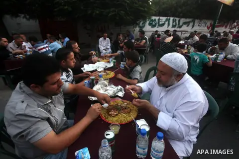 Families of Palestinian prisoners in Israeli jails attend the collective breaking fast organized by the Association of "Wa'ed" and funded by the Turkish relief "IHH" in front of the Red Cross headquarters during the holy...