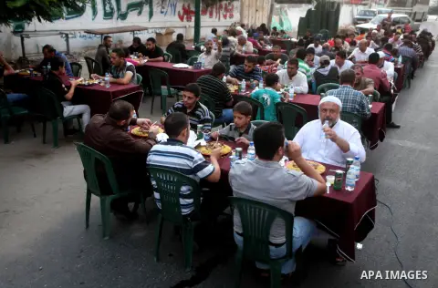 Families of Palestinian prisoners in Israeli jails attend the collective breaking fast organized by the Association of "Wa'ed" and funded by the Turkish relief "IHH" in front of the Red Cross headquarters during the holy...