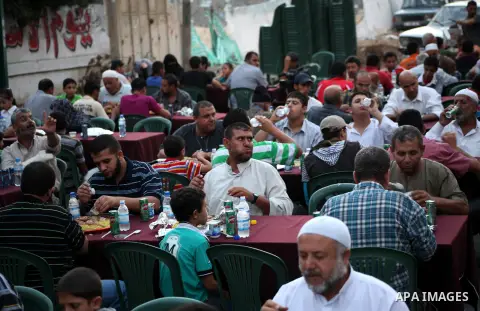 Families of Palestinian prisoners in Israeli jails attend the collective breaking fast organized by the Association of "Wa'ed" and funded by the Turkish relief "IHH" in front of the Red Cross headquarters during the holy...