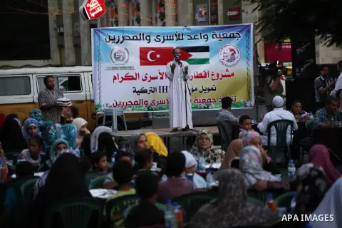 Families of Palestinian prisoners in Israeli jails attend the collective breaking fast organized by the Association of "Wa'ed" and funded by the Turkish relief "IHH" in front of the Red Cross headquarters during the holy...