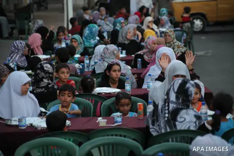 Families of Palestinian prisoners in Israeli jails attend the collective breaking fast organized by the Association of "Wa'ed" and funded by the Turkish relief "IHH" in front of the Red Cross headquarters during the holy...
