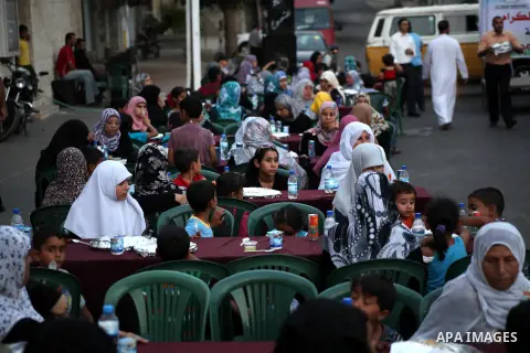 Families of Palestinian prisoners in Israeli jails attend the collective breaking fast organized by the Association of "Wa'ed" and funded by the Turkish relief "IHH" in front of the Red Cross headquarters during the holy...