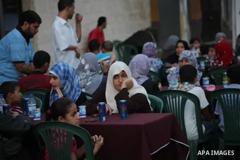 Families of Palestinian prisoners in Israeli jails attend the collective breaking fast organized by the Association of "Wa'ed" and funded by the Turkish relief "IHH" in front of the Red Cross headquarters during the holy...