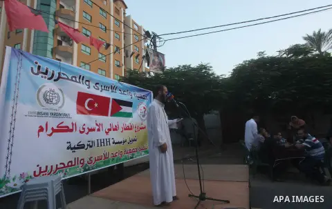 Families of Palestinian prisoners in Israeli jails attend the collective breaking fast organized by the Association of "Wa'ed" and funded by the Turkish relief "IHH" in front of the Red Cross headquarters during the holy...