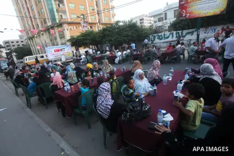 Families of Palestinian prisoners in Israeli jails attend the collective breaking fast organized by the Association of "Wa'ed" and funded by the Turkish relief "IHH" in front of the Red Cross headquarters during the holy...