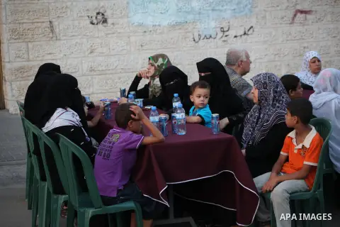 Families of Palestinian prisoners in Israeli jails attend the collective breaking fast organized by the Association of "Wa'ed" and funded by the Turkish relief "IHH" in front of the Red Cross headquarters during the holy...