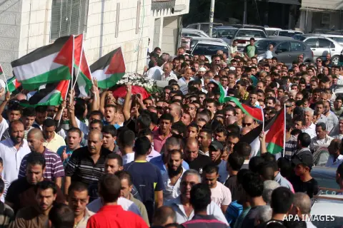 Palestinian mourners carry the body of Akram Badr, 46, during his funeral in the village of Beitillu near in the West Bank city of Ramallah, Tuesday, July 31, 2012. Badr was killed at a checkpoint by the Israeli security...