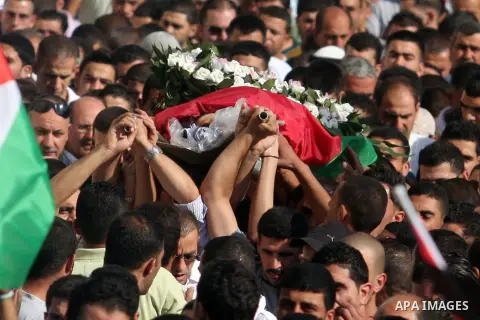 Palestinian mourners carry the body of Akram Badr, 46, during his funeral in the village of Beitillu near in the West Bank city of Ramallah, Tuesday, July 31, 2012. Badr was killed at a checkpoint by the Israeli security...
