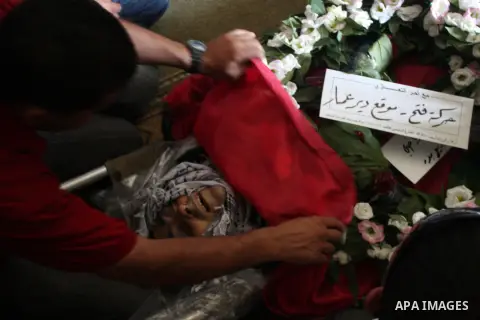Palestinian mourners over the body of Akram Badr, 46, during a funeral in the village of Beitillu near in the West Bank city of Ramallah, Tuesday, July 31, 2012. Badr was killed at a checkpoint by the Israeli security fo...