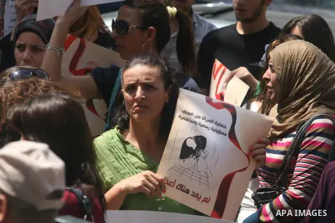 Palestinian women hold signs during a demonstration protesting violence against women held at the spot where a woman's throat was allegedly slashed by her husband on Monday, in the West Bank town of Bethlehem, Wednesday,...