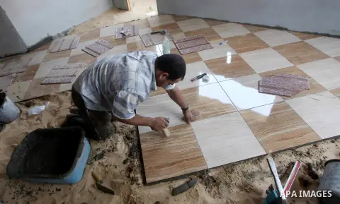 A Palestinian laborer works in flooring during the holy month of Ramadan, in Deir al-Balah in central Gaza Strip on 02 August 2012. During Ramadan, eating, drinking, sex and smoking is banned and restaurants are forbidde...