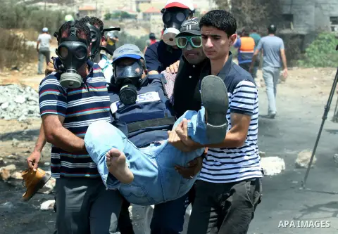 Palestinian protestors help a man injured by Israeli soldiers during a demonstration against the expropriation of Palestinian land by Israel in the village of Kafr Qaddum, near the West Bank city of Nablus on Aug. 03, 20...