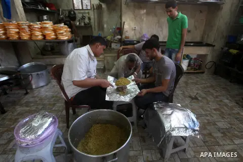 Palestinians prepare rice as they wait for customers several hours before Iftar, the breaking of the day long Ramadan fast in Gaza City, on Aug. 04, 2012. Muslims around the world refrain from eating, drinking and sexual...