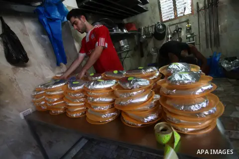 Palestinians prepare rice as they wait for customers several hours before Iftar, the breaking of the day long Ramadan fast in Gaza City, on Aug. 04, 2012. Muslims around the world refrain from eating, drinking and sexual...