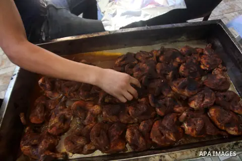 Palestinians prepare chicken as they wait for customers several hours before Iftar, the breaking of the day long Ramadan fast in Gaza City, on Aug. 04, 2012. Muslims around the world refrain from eating, drinking and sex...