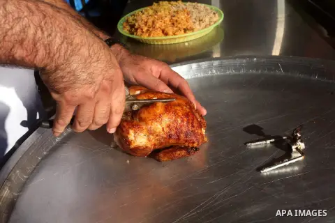 Palestinians prepare chicken as they wait for customers several hours before Iftar, the breaking of the day long Ramadan fast in Gaza City, on Aug. 04, 2012. Muslims around the world refrain from eating, drinking and sex...