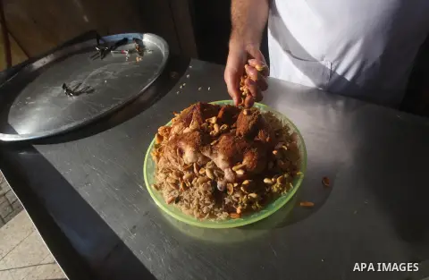 Palestinians prepare rice and chicken as they wait for customers several hours before Iftar, the breaking of the day long Ramadan fast in Gaza City, on Aug. 04, 2012. Muslims around the world refrain from eating, drinkin...