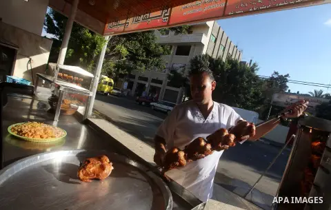 Palestinians prepare chicken as they wait for customers several hours before Iftar, the breaking of the day long Ramadan fast in Gaza City, on Aug. 04, 2012. Muslims around the world refrain from eating, drinking and sex...