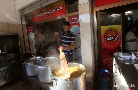 Palestinians prepare rice as they wait for customers several hours before Iftar, the breaking of the day long Ramadan fast in Gaza City, on Aug. 04, 2012. Muslims around the world refrain from eating, drinking and sexual...