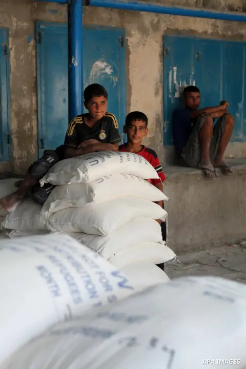 Palestinians receive their food aid at a UN Relief and Works Agency (UNRWA) warehouse in the Shati refugee camp, in Gaza City, on Aug. 05, 2012. UNRWA launched Sunday its Gaza Ramadan Appeal for 5000 food parcels in orde...