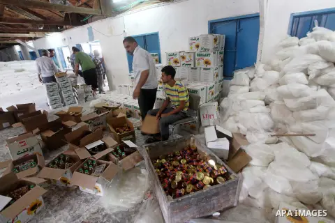 Palestinians receive their food aid at a UN Relief and Works Agency (UNRWA) warehouse in the Shati refugee camp, in Gaza City, on Aug. 05, 2012. UNRWA launched Sunday its Gaza Ramadan Appeal for 5000 food parcels in orde...