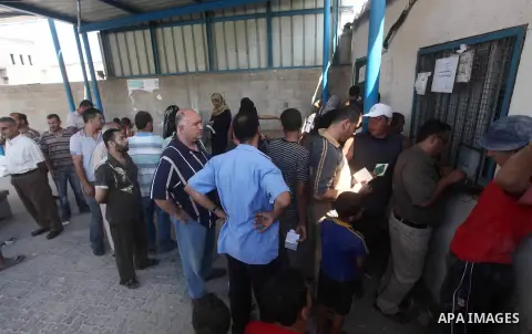 Palestinians receive their food aid at a UN Relief and Works Agency (UNRWA) warehouse in the Shati refugee camp, in Gaza City, on Aug. 05, 2012. UNRWA launched Sunday its Gaza Ramadan Appeal for 5000 food parcels in orde...