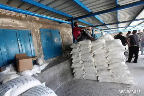 Palestinians receive their food aid at a UN Relief and Works Agency (UNRWA) warehouse in the Shati refugee camp, in Gaza City, on Aug. 05, 2012. UNRWA launched Sunday its Gaza Ramadan Appeal for 5000 food parcels in orde...