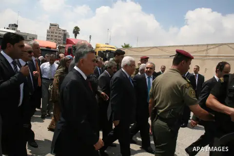 Palestinian President Mahmoud Abbas, accompanied by other officials as he inspects a convoy of trucks carrying food and medical supplies, which reportedly were provided by the Palestinian people, leaving Ramallah bound f...