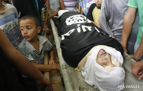 Mourners over the body of a Palestinian militant Eid Hejazi during his funeral in Rafah, southern Gaza Strip, Sunday, Aug. 5, 2012. Hejazi was killed on an Israeli air strike on Sunday and was a member of the Popular Res...