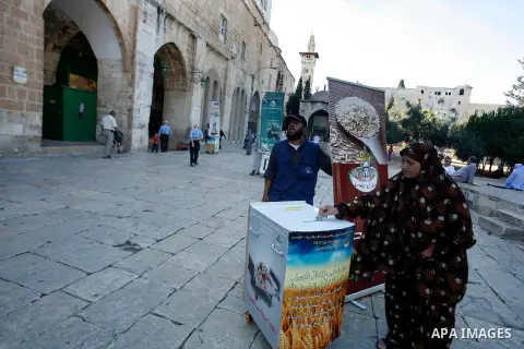A Palestinian woman donates her alms known as "Zakat" during Ramadan in front of al-Aqsa Mosque in Jerusalem on 05 August 2012. Muslims around the world abstain from eating, drinking and conducting sexual relations from...