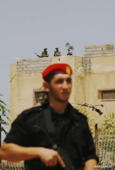 A Palestinian security officer (front) and Egyptian soldiers (rear) stand guard on the border between Egypt and the southern Gaza Strip, near Rafah August 6, 2012. Egypt has closed the terminal, the only gateway for Gaza...