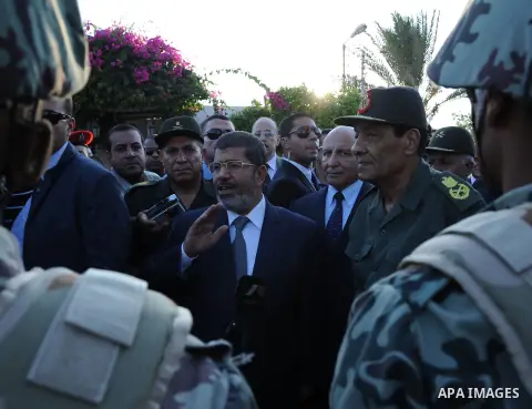 Egypt's President Mohamed Mursi gestures, while Field Marshal Hussein Tantawi, and an army general look on at a checkpoint in al-Arish August 6, 2012. Egypt branded Islamist gunmen who killed 16 police near the Israeli b...