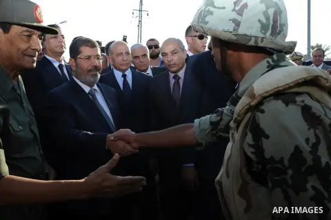 Egypt's President Mohamed Mursi gestures, while Field Marshal Hussein Tantawi, and an army general look on at a checkpoint in al-Arish August 6, 2012. Egypt branded Islamist gunmen who killed 16 police near the Israeli b...