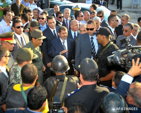 Egypt's President Mohamed Mursi gestures, while Field Marshal Hussein Tantawi, and an army general look on at a checkpoint in al-Arish August 6, 2012. Egypt branded Islamist gunmen who killed 16 police near the Israeli b...