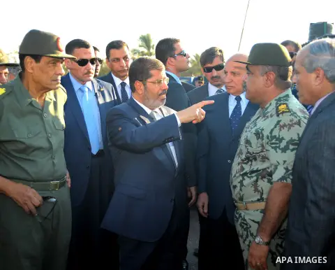 Egypt's President Mohamed Mursi gestures, while Field Marshal Hussein Tantawi, and an army general look on at a checkpoint in al-Arish August 6, 2012. Egypt branded Islamist gunmen who killed 16 police near the Israeli b...