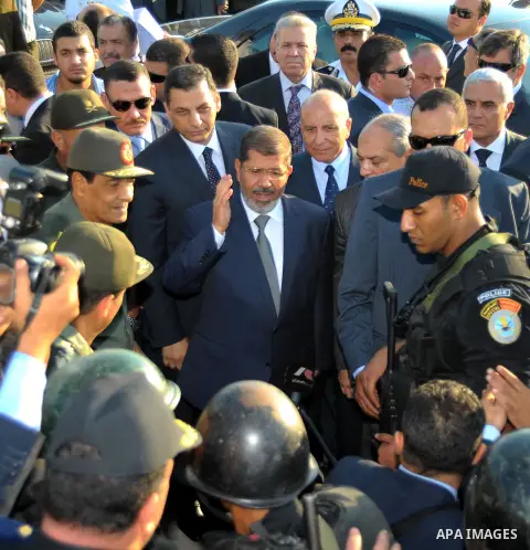 Egypt's President Mohamed Mursi gestures, while Field Marshal Hussein Tantawi, and an army general look on at a checkpoint in al-Arish August 6, 2012. Egypt branded Islamist gunmen who killed 16 police near the Israeli b...