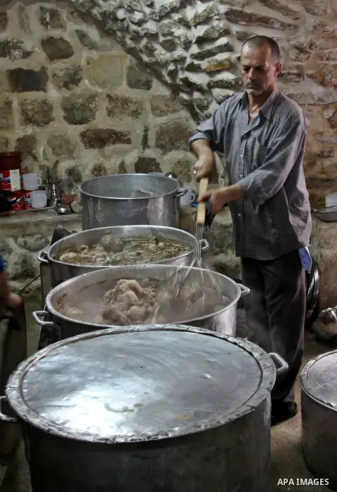 Palestinians prepare meals for distribution to poor families during Ramadan at a charity kitchen in the West Bank city of Nablus 07 August 2012. Muslims from all over the world are observing the holy month of Ramadan whi...