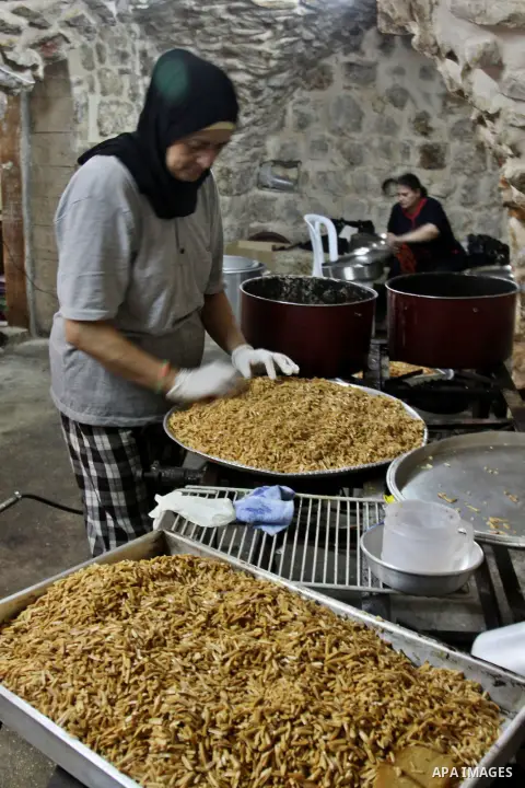 Palestinians prepare meals for distribution to poor families during Ramadan at a charity kitchen in the West Bank city of Nablus 07 August 2012. Muslims from all over the world are observing the holy month of Ramadan whi...