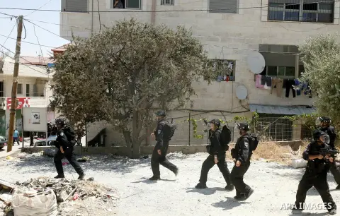 Israeli policemen run with their weapons during stormed in the West Bank town of Issawiya, in the West Bank, on Aug. 07, 2012. Photo by Mahfouz Abu Turk
