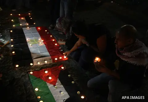 Palestinian youths light candles and place them on Palestinian and Egyptian flags on August 8, 2012, in the West Bank city of Ramallah, in memory of the 16 Egyptian soldiers who were killed in a militant ambush on August...