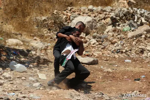 Palestinians hurl stones at Israeli troops, not seen, during a Democratic Front for the Liberation of Palestine (DFLP) demonstration supporting prisoners in Israeli jails outside the Ofer military prison, near the West B...