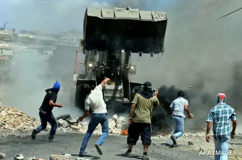 Palestinian protesters throw stones at Israeli bulldozer during a demonstration against the expropriation of Palestinian land by Israel in the village of Kafr Qaddum, near the West Bank city of Nablus, on August 10, 2012...