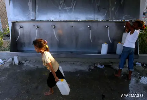 Palestinian children fill their bottles a potable water at a water purification station, in Rafah refugee camp southern Gaza Strip, on 11 August 2012. Palestinians suffer from the severe lack of potable water. Photo by E...