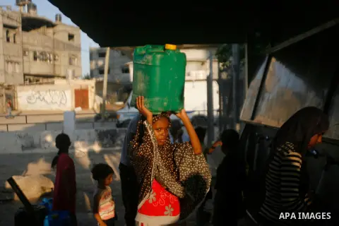 Palestinian children fill their bottles a potable water at a water purification station, in Rafah refugee camp southern Gaza Strip, on 11 August 2012. Palestinians suffer from the severe lack of potable water. Photo by E...
