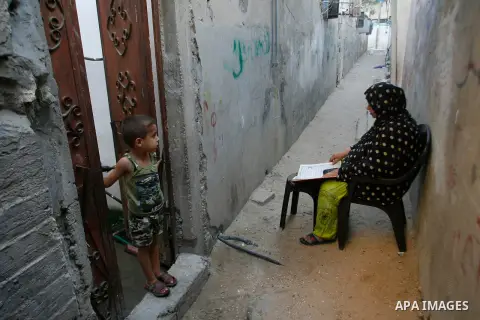 Palestinian woman reads the holy Qur'an in front of her house during the fasting month of Ramadan in Rafah refugee camp southern Gaza Strip, on 11 August 2012. Photo by Eyad Al Baba