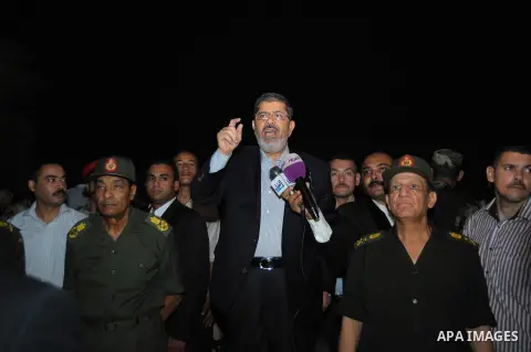 Newly elected Egyptian President Mohamed Mursi is flanked by Field Marshal Hussein Tantawi (L) and Egyptian Armed Forces Chief of Staff Sami Anan (R) as he talks to the soldiers at a checkpoint in al-Arish August 10, 201...