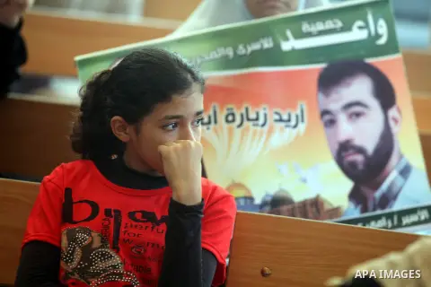 A Palestinian girl holds a picture of her relative prisoner in Israeli jails as she gather with Palestinians in an activity calling for their liberty at the Red Cross headquarters in Gaza City on 13 August 2012. Photo by...